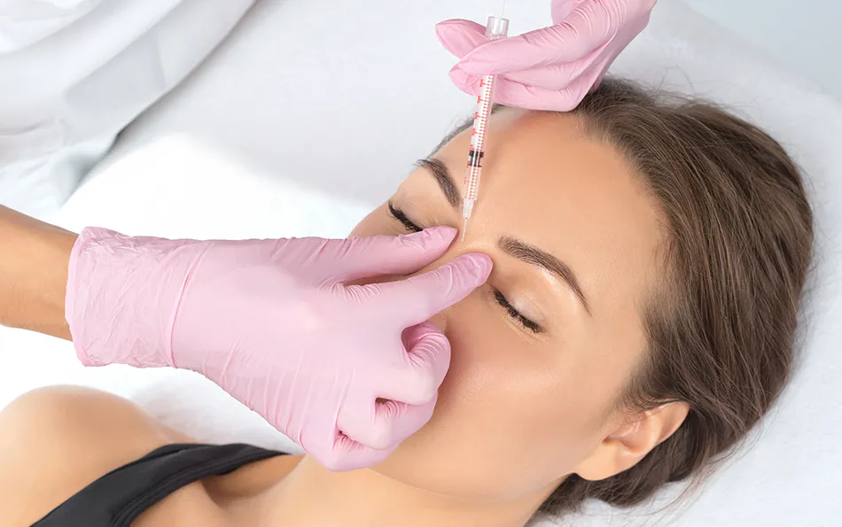 Arten von Unterspritzungen Filler Jemand setzt eine Spritze am Nasenrücken einer liegenden weiblichen Person