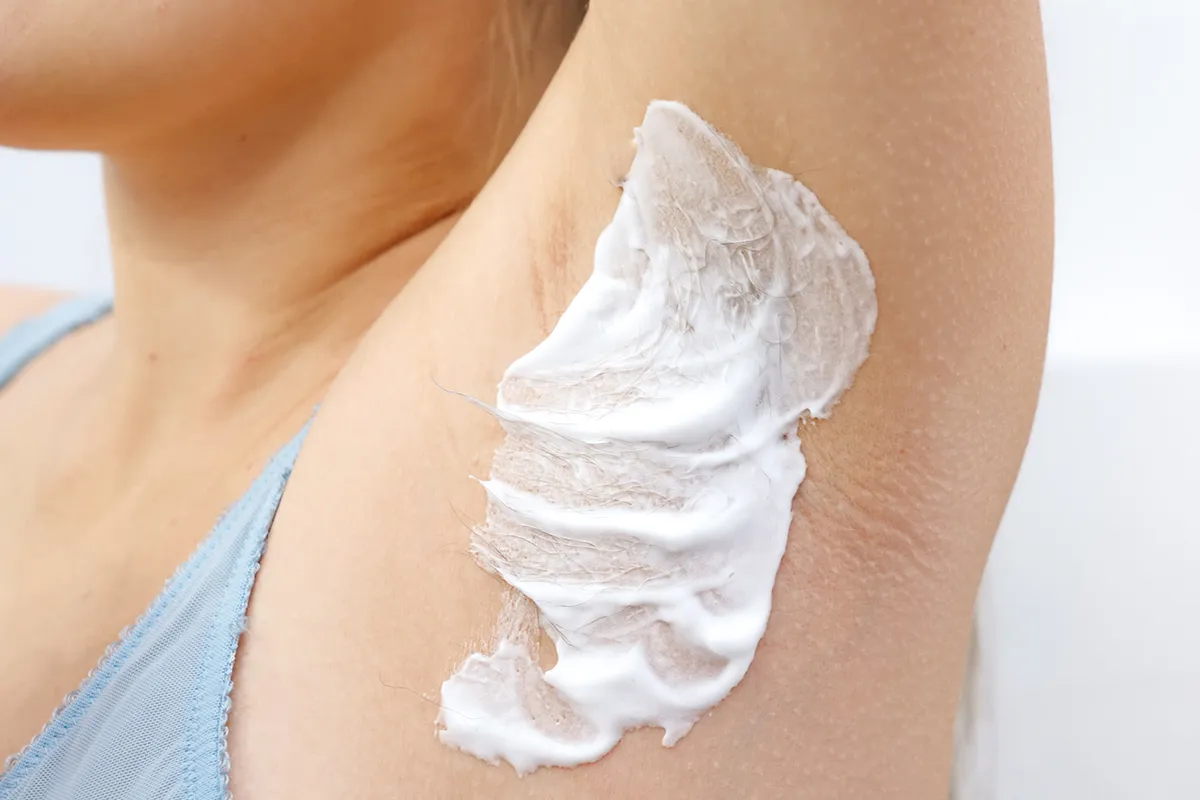 Aufgetragene Creme in der Achselhöhle einer weiblichen Person