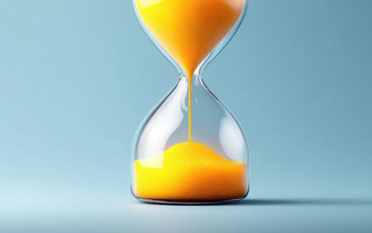 Eine gerendertes Bild einer Sanduhr mit gelbem Sand, halb durchgelaufen